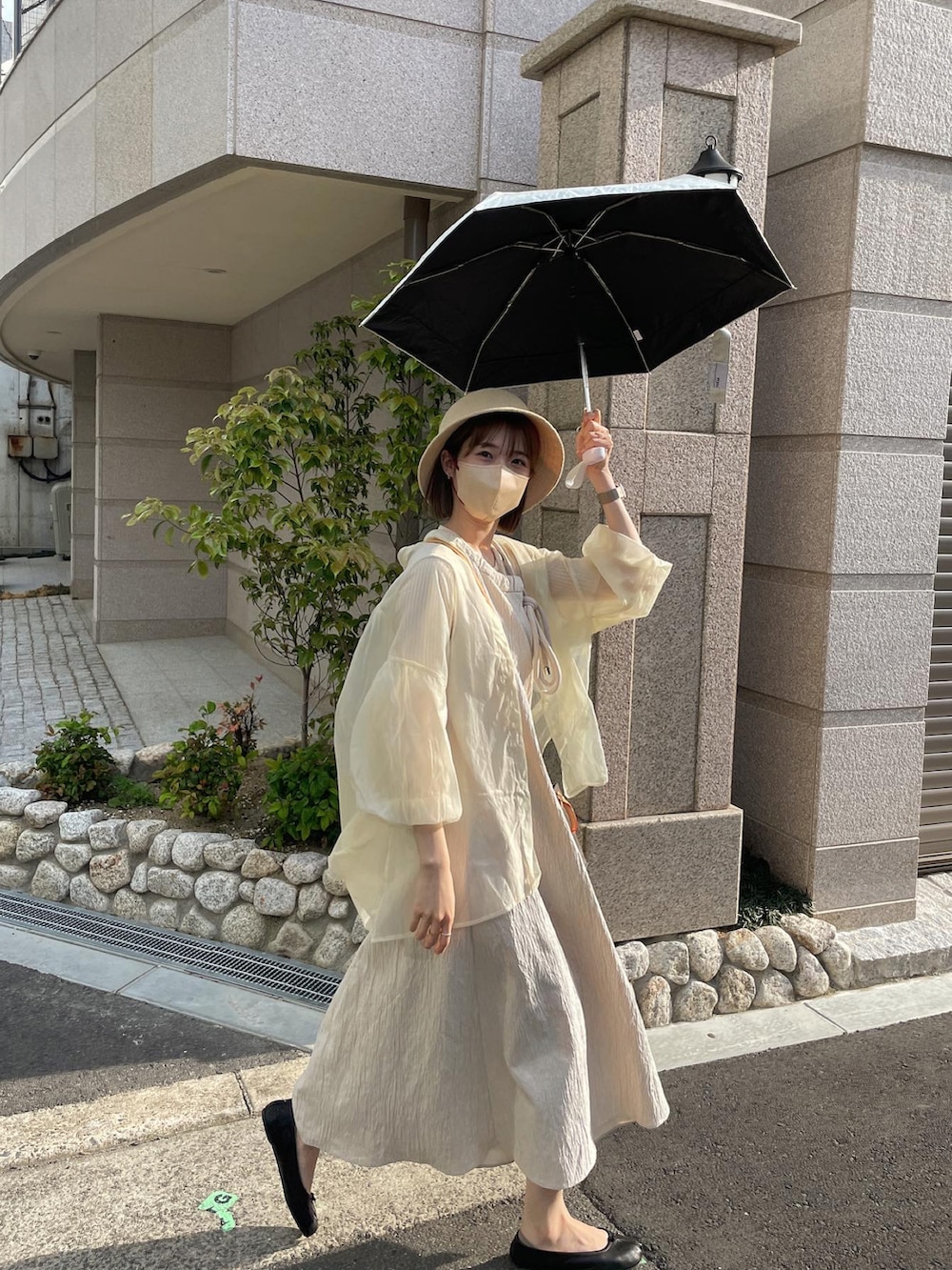 ホワイト系のシャツ/ブラウス、ベージュ系のワンピース、ブラック系のバレエシューズを着用したレディースの春コーディネートの2枚目の写真