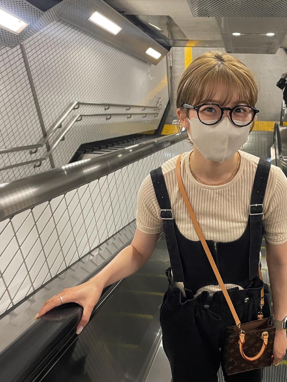 ベージュ系のTシャツ/カットソー、ブラック系のサロペット/オーバーオール、ブラウン系のサンダルを着用したレディースの夏コーディネートの3枚目の写真