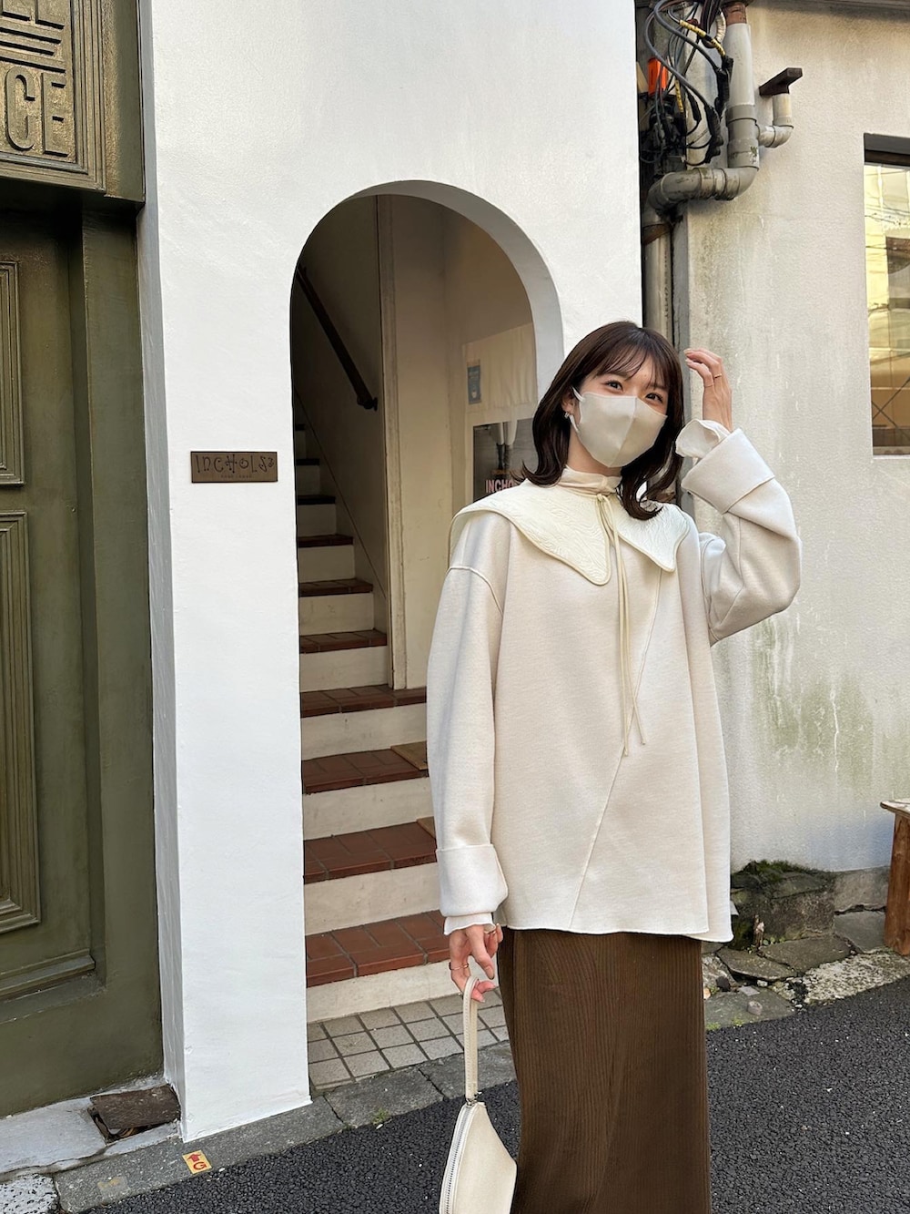 ブラウン系のスカート、ブラック系のブーツ、ベージュ系のノーカラージャケットを着用したレディースの冬コーディネートの5枚目の写真