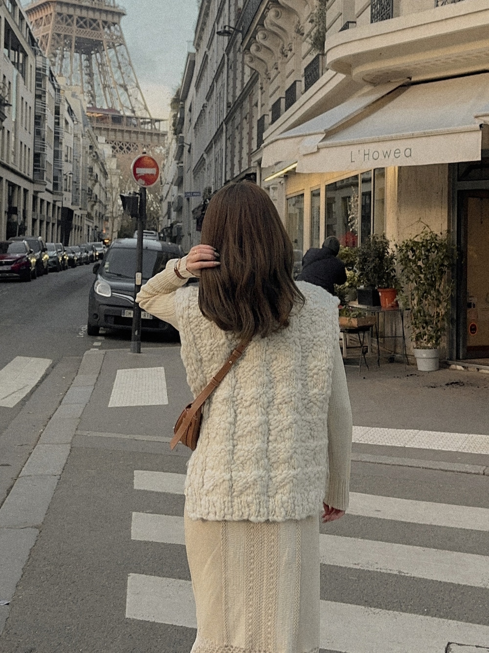 ホワイト系のニット/セーター、ブラウン系のバッグ、ブラウン系のブーツを着用したレディースの冬コーディネートの4枚目の写真