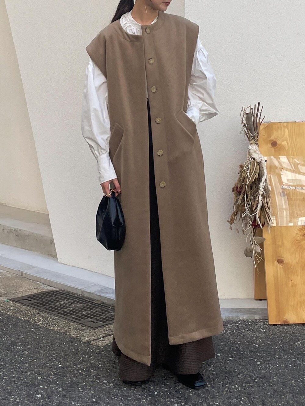 ベージュ系のローファー、ブラック系のショルダーバッグ、ブラウン系のスカートを着用したレディースの秋コーディネートの4枚目の写真