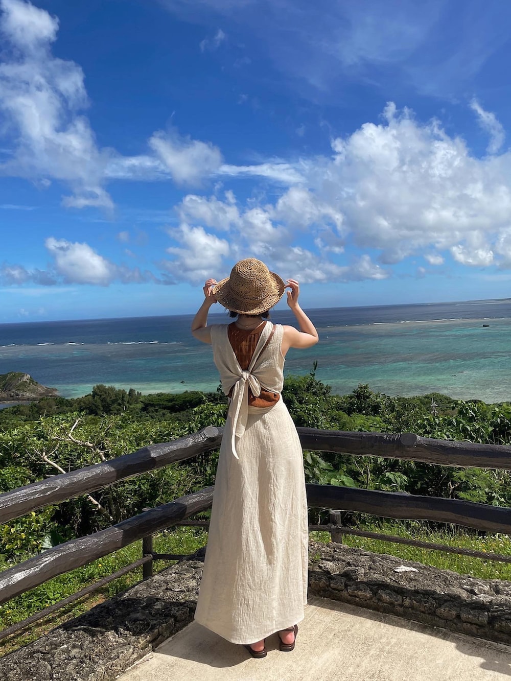 ホワイト系のワンピース、ブラウン系のタンクトップ、ブラウン系のサンダルを着用したレディースの夏コーディネートの3枚目の写真