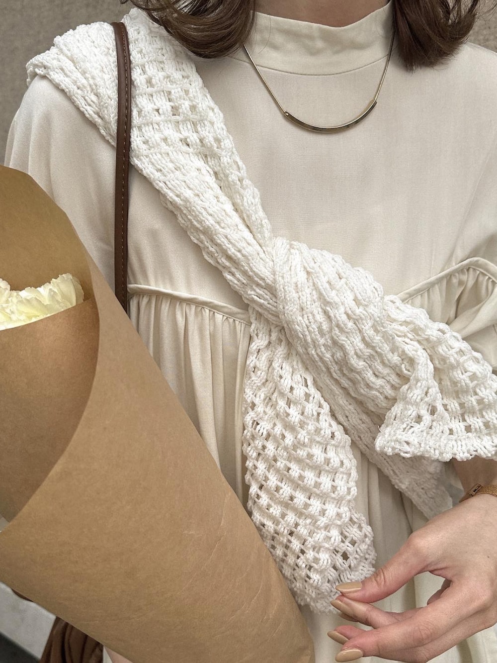 ベージュ系のサンダル、ブラウン系のショルダーバッグ、ホワイト系のカーディガン/ボレロを着用したレディースの春コーディネートの4枚目の写真