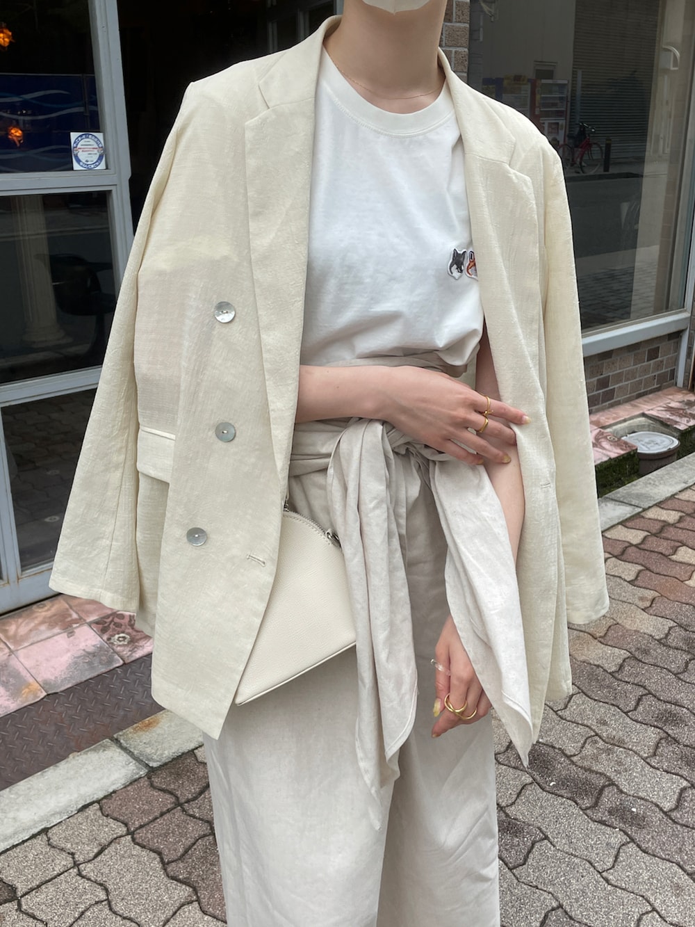 ホワイト系のTシャツ/カットソー、ベージュ系のスカート、ベージュ系のサンダルを着用したレディースの春コーディネートの3枚目の写真