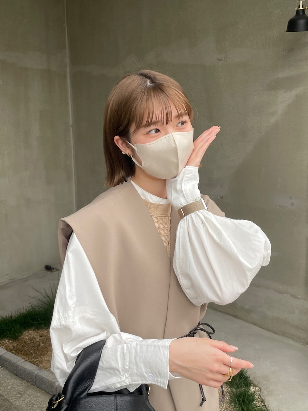 ホワイト系のシャツ/ブラウス、ブラック系のショルダーバッグ、ベージュ系のベストを着用したレディースの春コーディネートの3枚目の写真