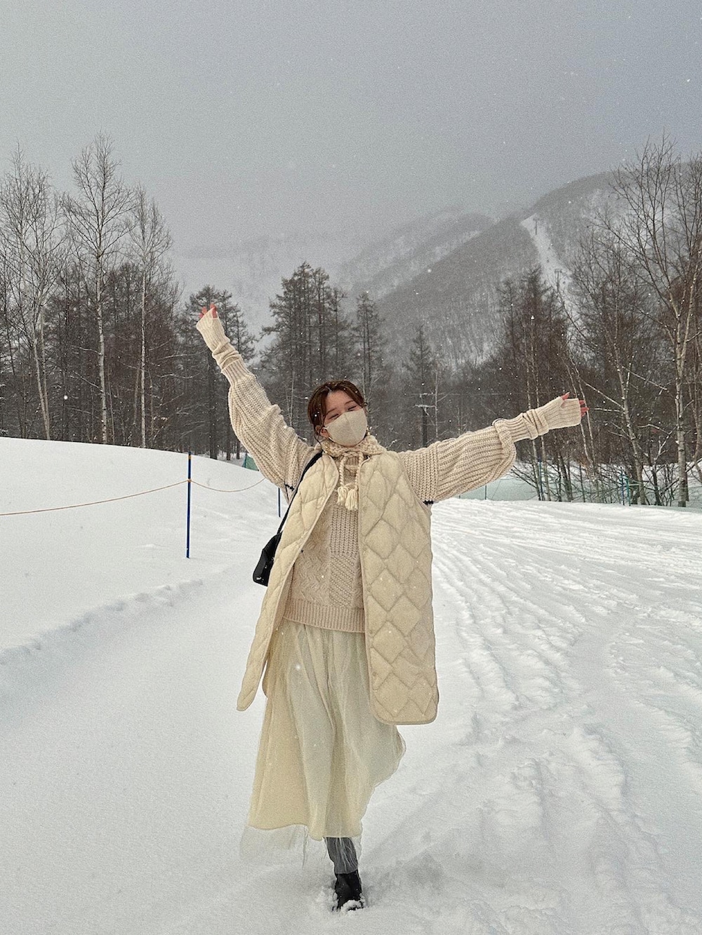 ホワイト系のニット/セーター、ホワイト系のスカート、ブラック系のブーツを着用したレディースの冬コーディネートの4枚目の写真