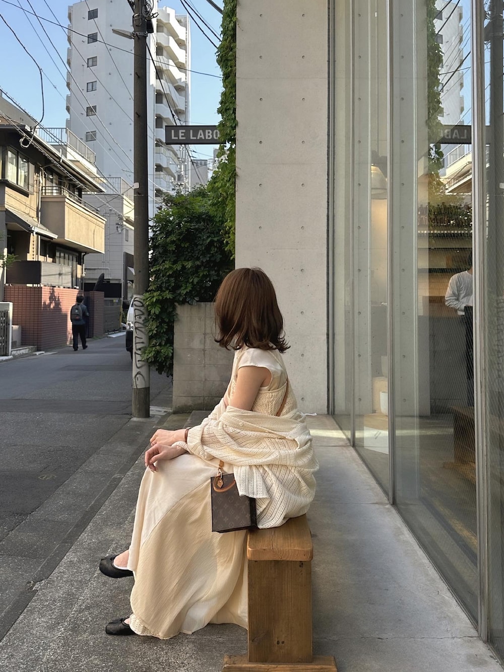 ブラック系のバレエシューズ、ベージュ系のシャツワンピース、ベージュ系のパンツを着用したレディースの春コーディネートの2枚目の写真