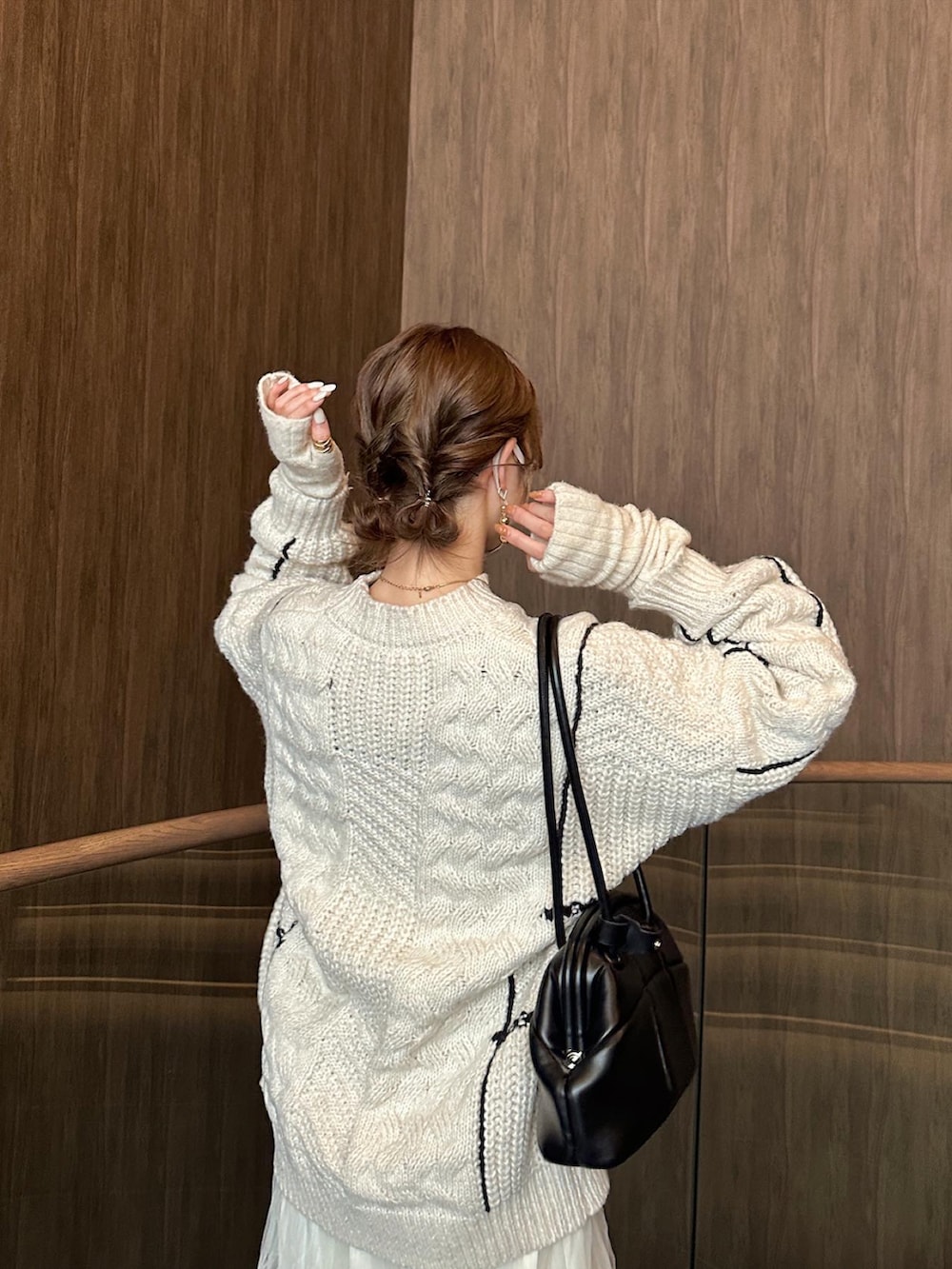 ホワイト系のニット/セーター、ホワイト系のスカート、ブラック系のブーツを着用したレディースの冬コーディネートの3枚目の写真