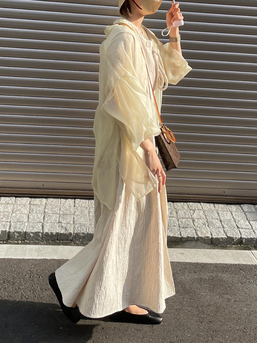 ホワイト系のシャツ/ブラウス、ベージュ系のワンピース、ブラック系のバレエシューズを着用したレディースの春コーディネートの3枚目の写真