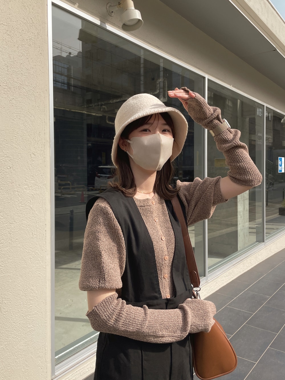 ピンク系のニット/セーター、ブラック系のサロペット/オーバーオール、ベージュ系のハットを着用したレディースの春コーディネートの2枚目の写真