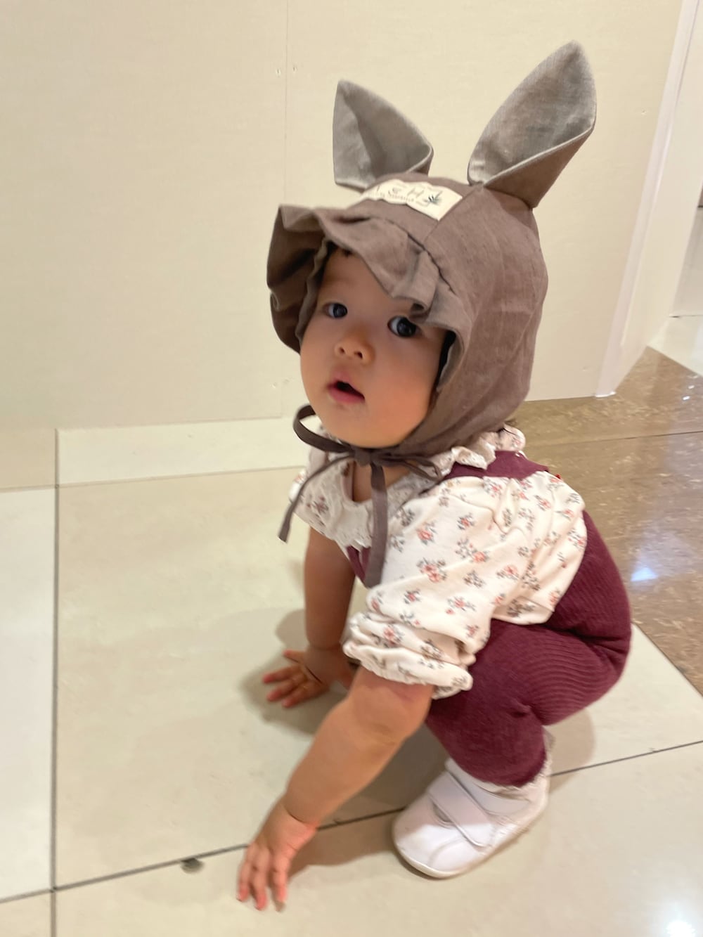 ホワイト系のTシャツ/カットソー、ホワイト系のスニーカー、ブラウン系の帽子を着用したキッズの秋コーディネートの2枚目の写真