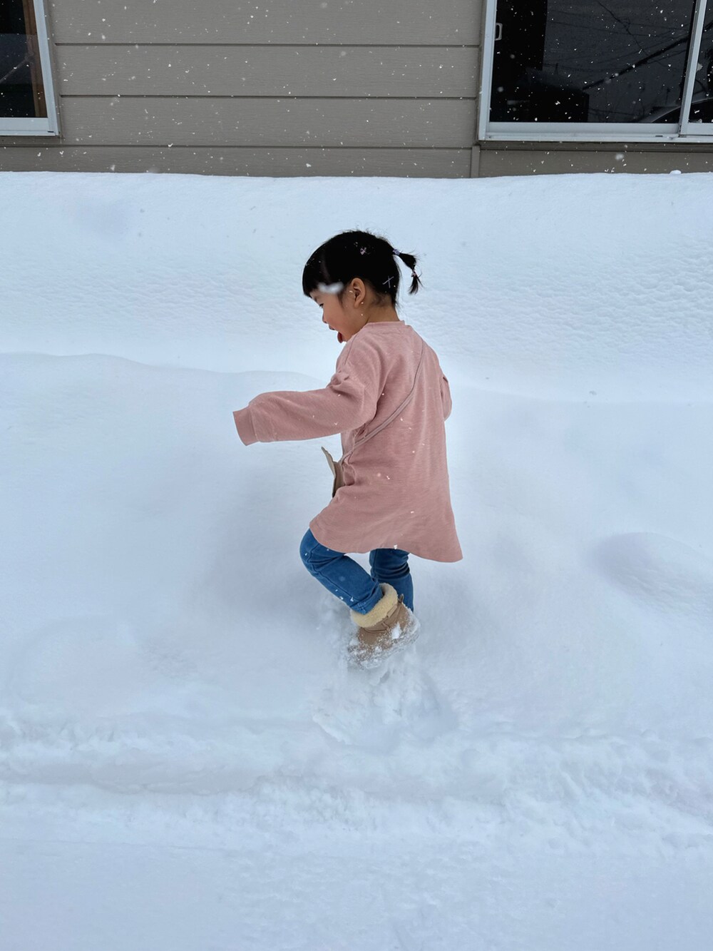 ピンク系のチュニック、ベージュ系のブーツ、ピンク系のダウンジャケット/コートを着用したキッズの冬コーディネートの2枚目の写真