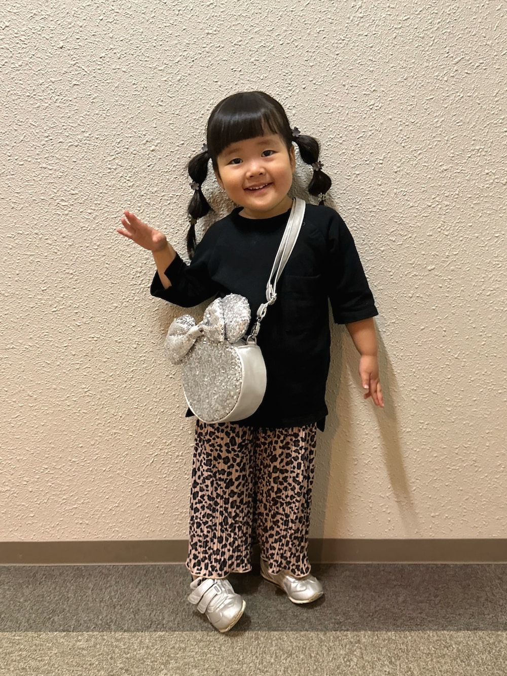 ブラック系のワンピース、ブラウン系のパンツ、シルバー系のショルダーバッグを着用したキッズの秋コーディネートの4枚目の写真