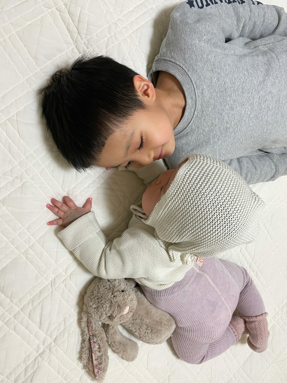 ホワイト系のカーディガン/ボレロ、グレー系のニットキャップ/ビーニー、パープル系のレギンス/スパッツを着用したキッズの冬コーディネートの5枚目の写真