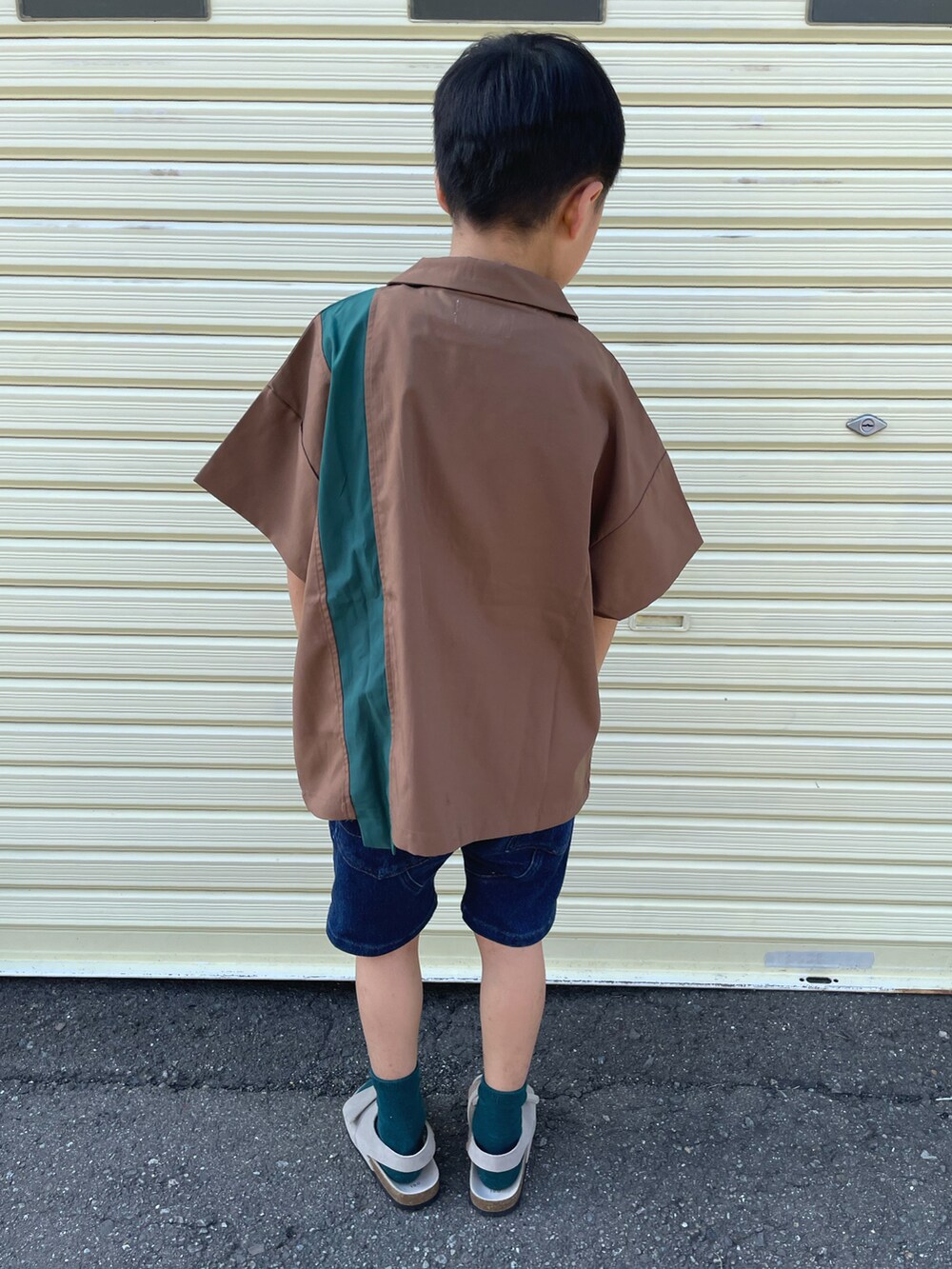 ブラウン系のシャツ/ブラウス、ホワイト系のタンクトップ、ブルー系のデニムパンツを着用したキッズの秋コーディネートの2枚目の写真