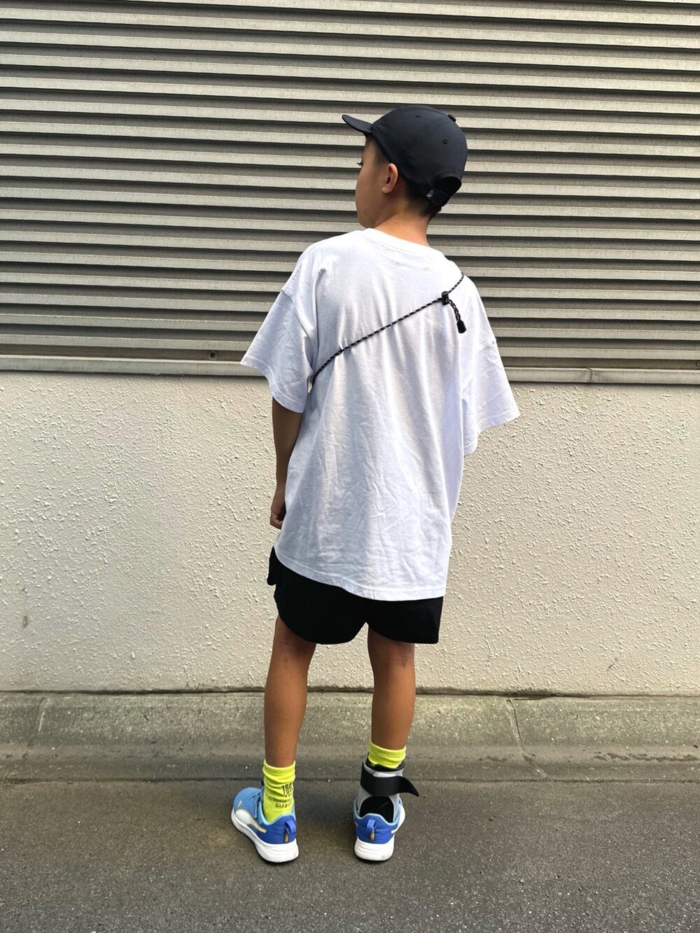 ブルー系のスニーカー、ホワイト系のTシャツ/カットソー、ブラック系のパンツを着用したキッズの夏コーディネートの3枚目の写真