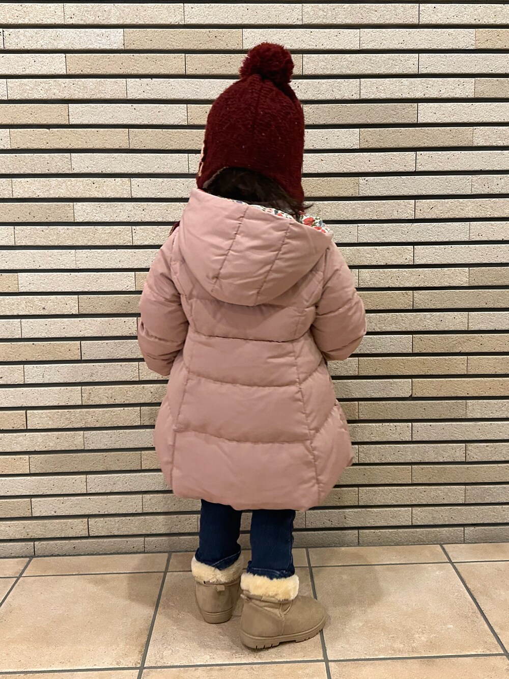 ピンク系のダウンジャケット/コート、ブルー系のその他パンツ、ベージュ系のブーツを着用したキッズの冬コーディネートの5枚目の写真