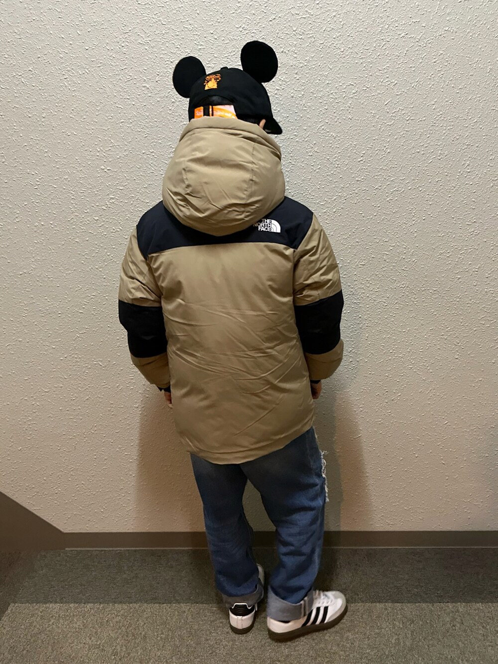 ブルー系のデニムパンツ、ホワイト系のスニーカー、ベージュ系のダウンジャケット/コートを着用したキッズの秋コーディネートの3枚目の写真