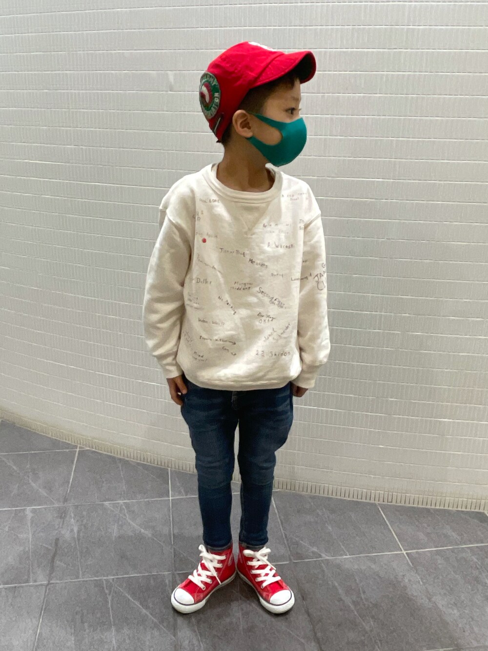 ホワイト系のスウェット、ブルー系のデニムパンツ、レッド系のスニーカーを着用したキッズの春コーディネートの2枚目の写真