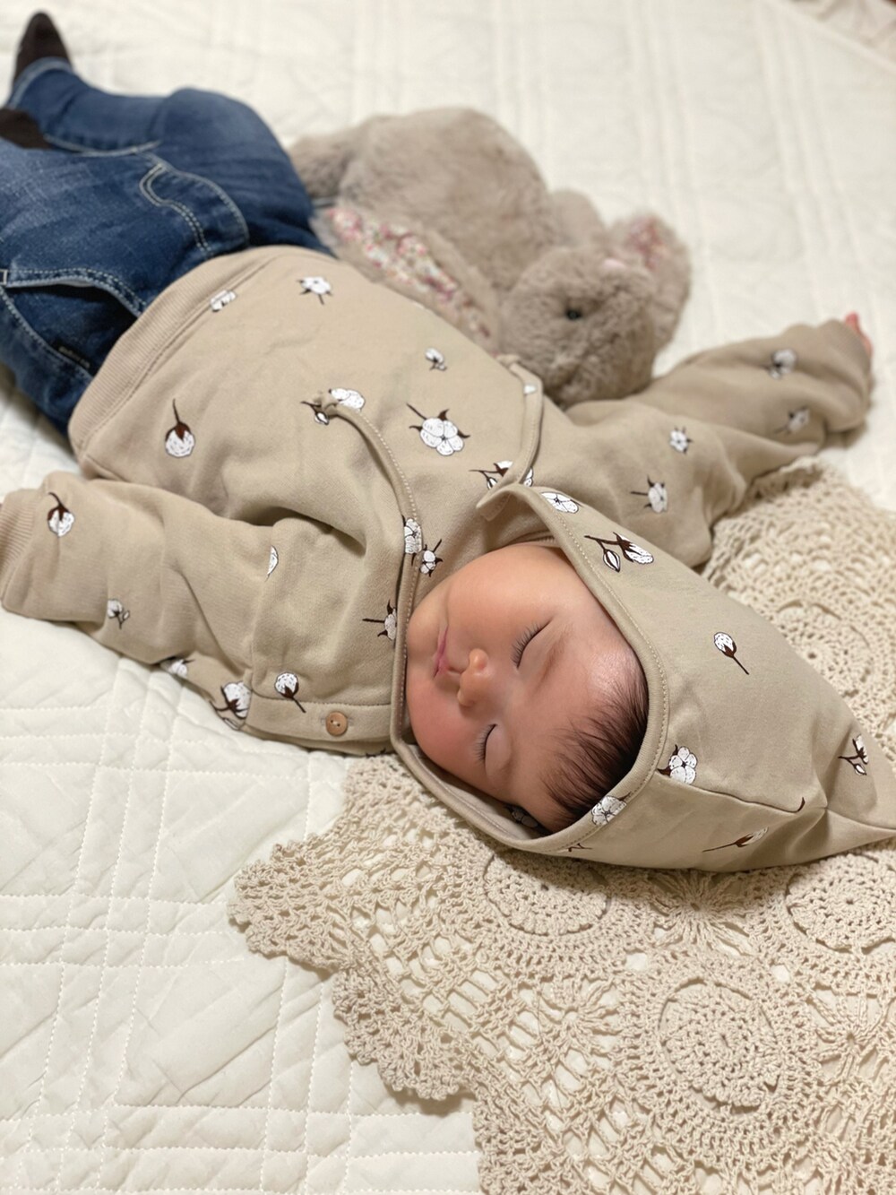 ベージュ系のトップス、ブルー系のデニムパンツ、ベージュ系のニットキャップ/ビーニーを着用したキッズの秋コーディネートの2枚目の写真