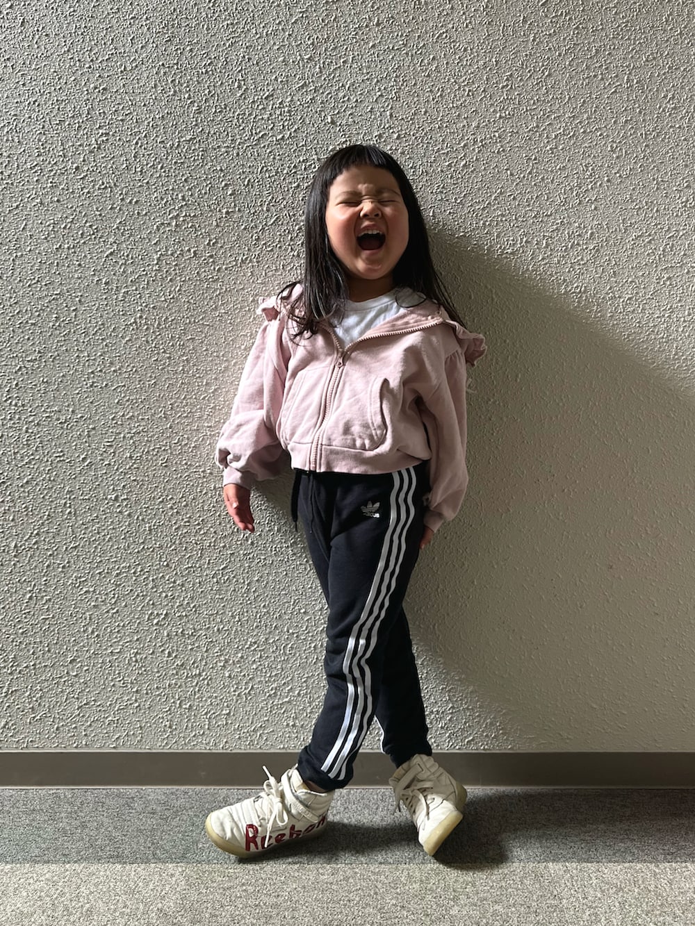 ピンク系のパーカー、ブラック系のジャージ、レッド系のスニーカーを着用したキッズの夏コーディネートの4枚目の写真