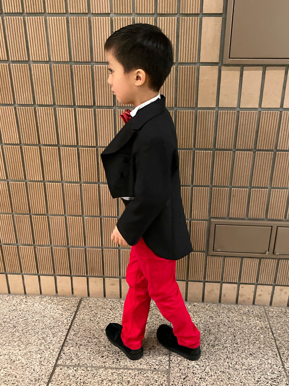 ブラック系のスーツセット、レッド系のパンツ、ブラック系のその他シューズを着用したキッズの春コーディネートの2枚目の写真