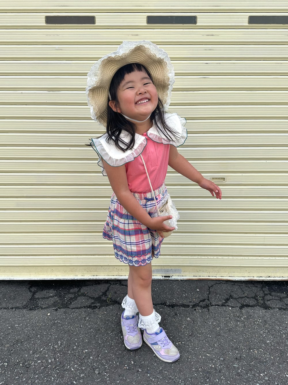 パープル系のスニーカー、ピンク系のTシャツ/カットソー、ホワイト系のショルダーバッグを着用したキッズの夏コーディネートの3枚目の写真