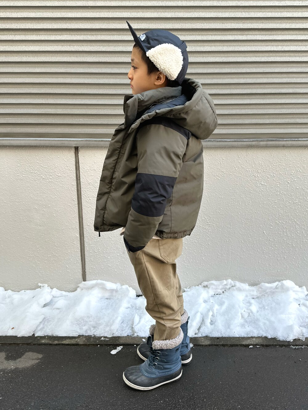 グリーン系のダウンジャケット/コート、ホワイト系のスウェット、ベージュ系のチノパンツを着用したキッズの春コーディネートの3枚目の写真