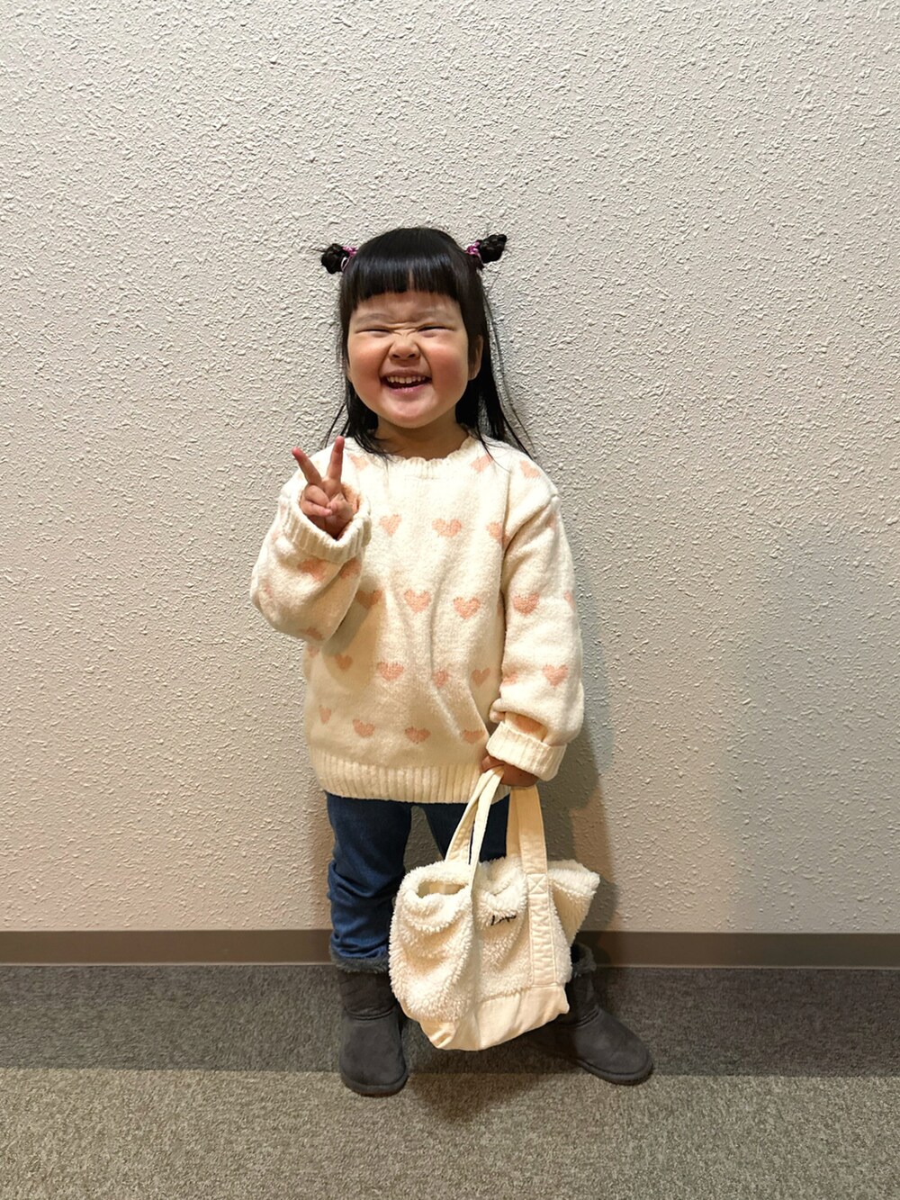 ホワイト系のニット/セーター、ホワイト系のトートバッグ、ブルー系のレギンス/スパッツを着用したキッズの冬コーディネートの3枚目の写真