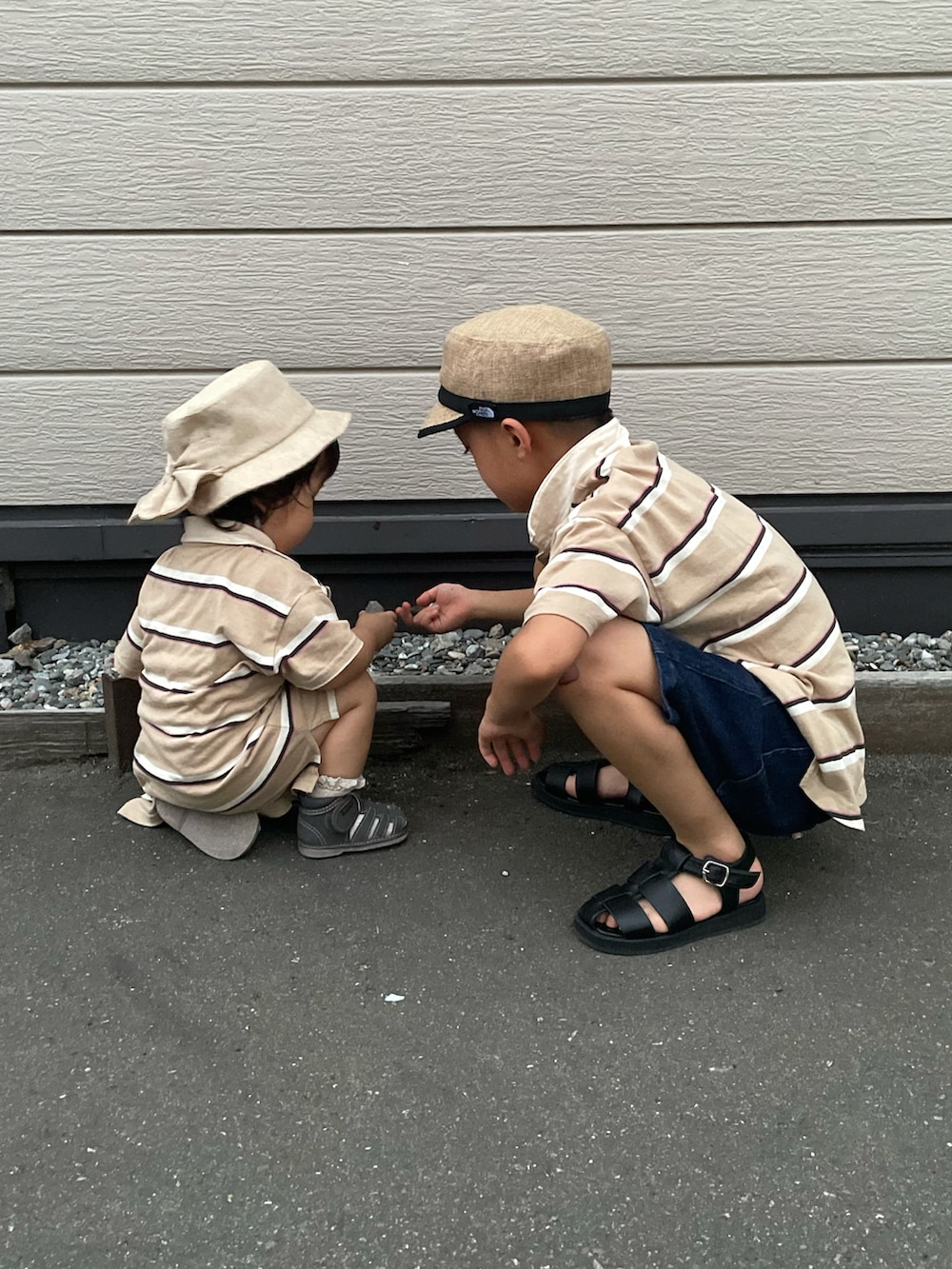 ベージュ系のポロシャツ、ブルー系のデニムパンツ、ブラック系のサンダルを着用したキッズの秋コーディネートの2枚目の写真