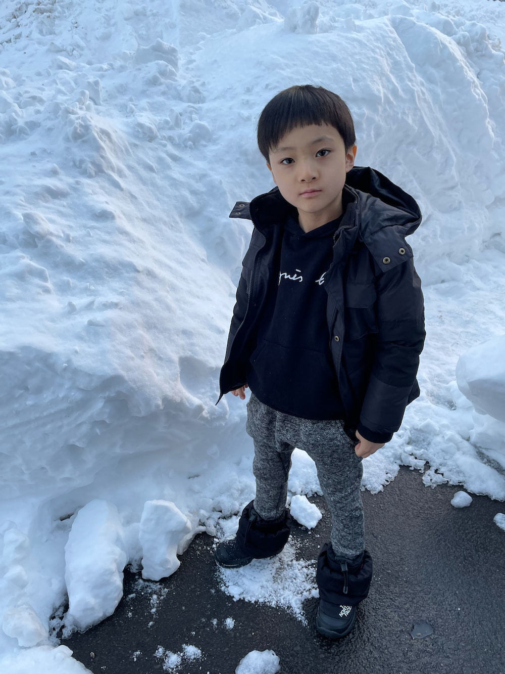 ブラック系のパーカー、ブラック系のダウンジャケット/コート、ブラック系のその他パンツを着用したキッズの冬コーディネートの2枚目の写真