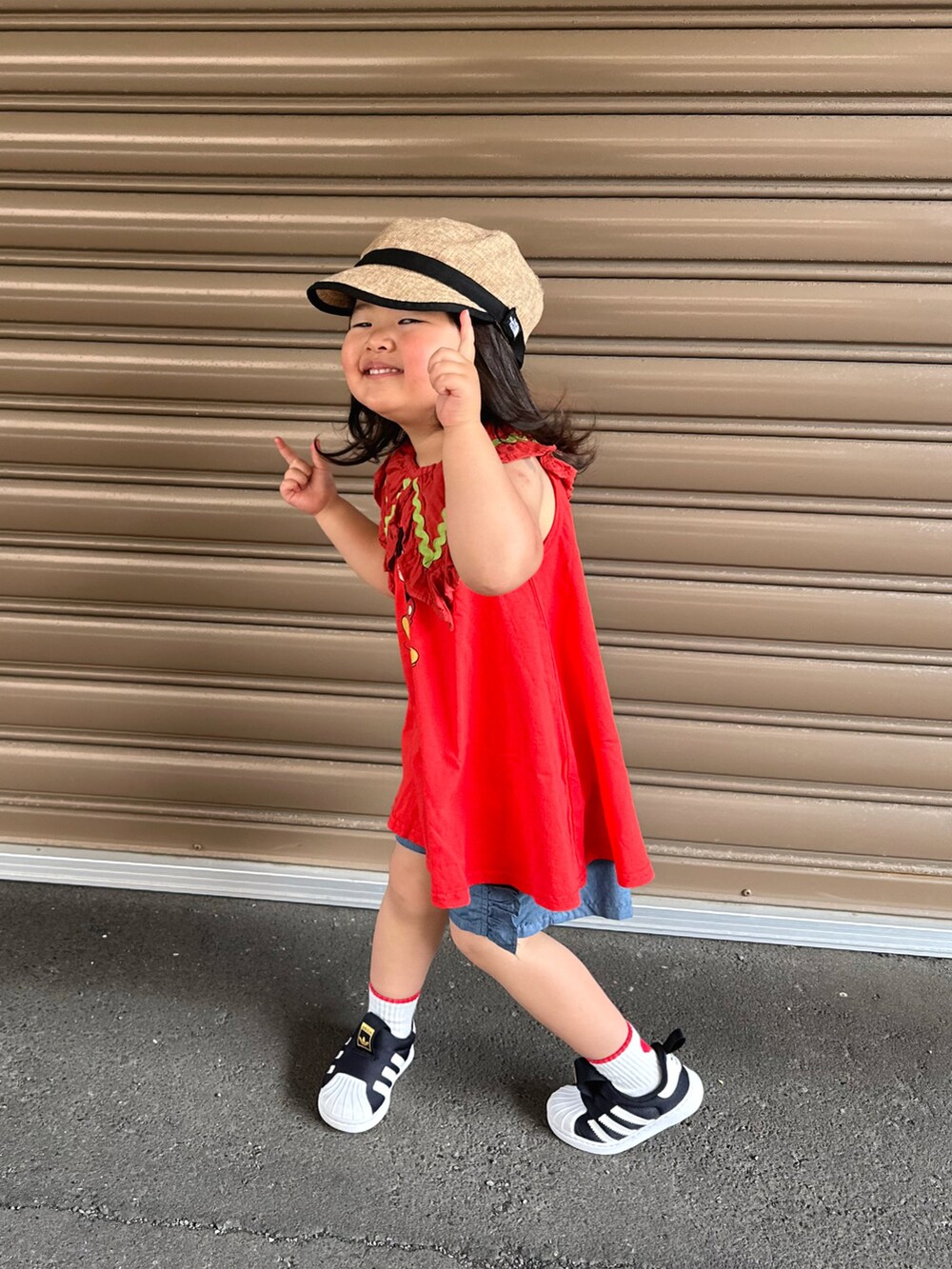 レッド系のワンピース、ブルー系のその他パンツ、ブラック系のスニーカーを着用したキッズの夏コーディネートの2枚目の写真