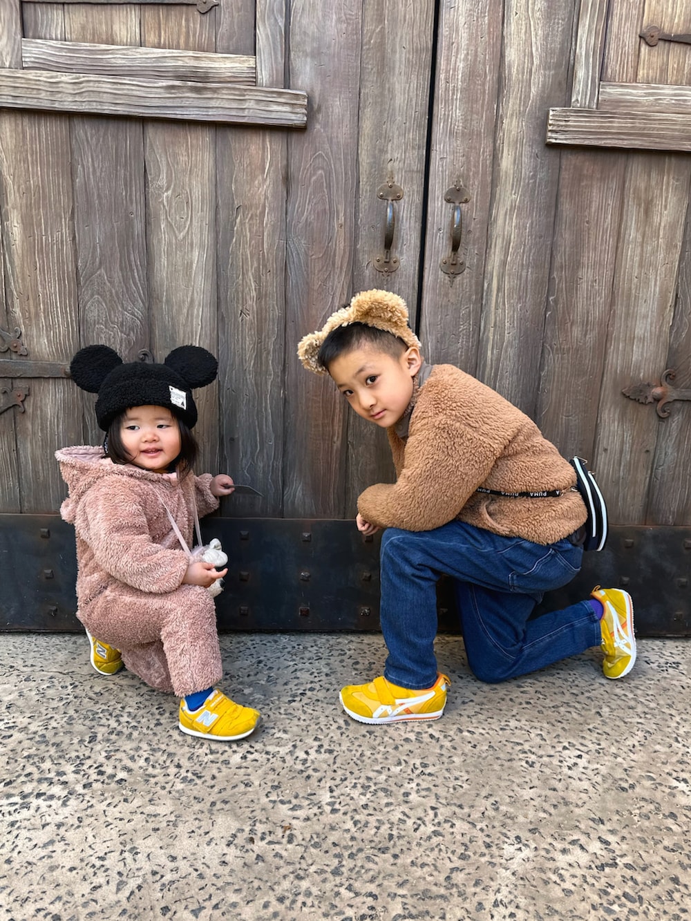 ブラウン系のその他アウター、ブルー系のTシャツ/カットソー、イエロー系のスニーカーを着用したキッズの冬コーディネートの3枚目の写真