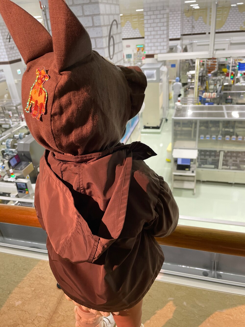ブラウン系のナイロンジャケット、ホワイト系のその他パンツ、ホワイト系のスニーカーを着用したキッズの秋コーディネートの3枚目の写真