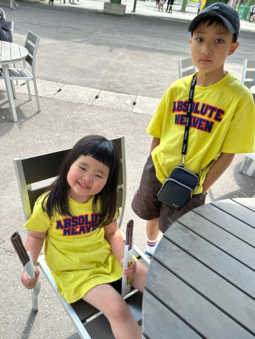イエロー系のTシャツ/カットソー、イエロー系のワンピース、ブラウン系のパンツを着用したキッズの夏コーディネートの4枚目の写真