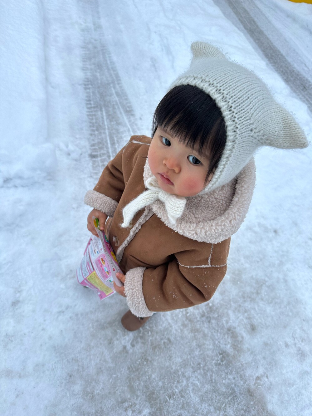 イエロー系のチュニック、ブラウン系のシューズ、ベージュ系のムートンコートを着用したキッズの冬コーディネートの4枚目の写真