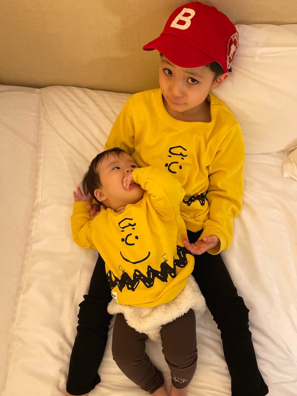 イエロー系のスウェット、ブラック系のその他パンツ、ホワイト系のパーカーを着用したキッズの秋コーディネートの4枚目の写真