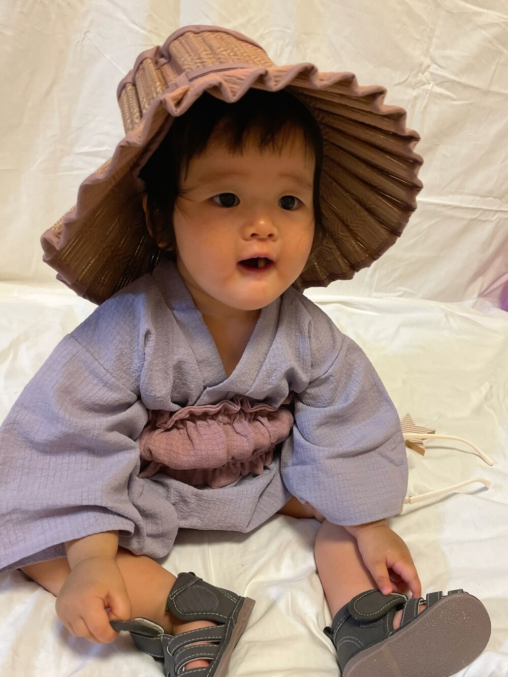 グレー系のサンダル、ベージュ系のバッグ、パープル系の帽子を着用したキッズの夏コーディネートの4枚目の写真