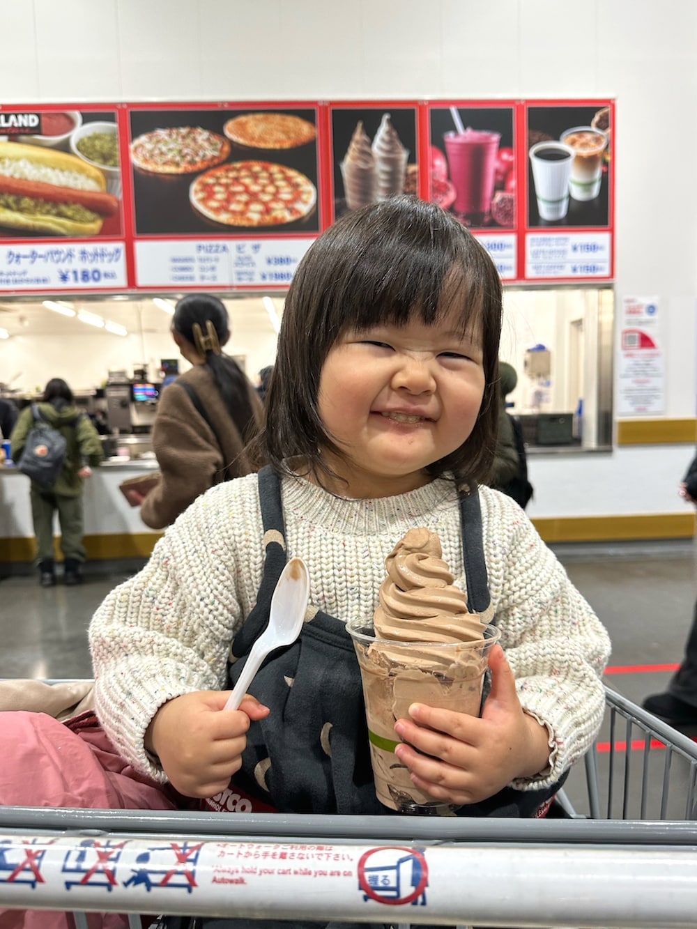 ホワイト系のニット/セーター、ブラック系のワンピース、ベージュ系のブーツを着用したキッズの冬コーディネートの2枚目の写真