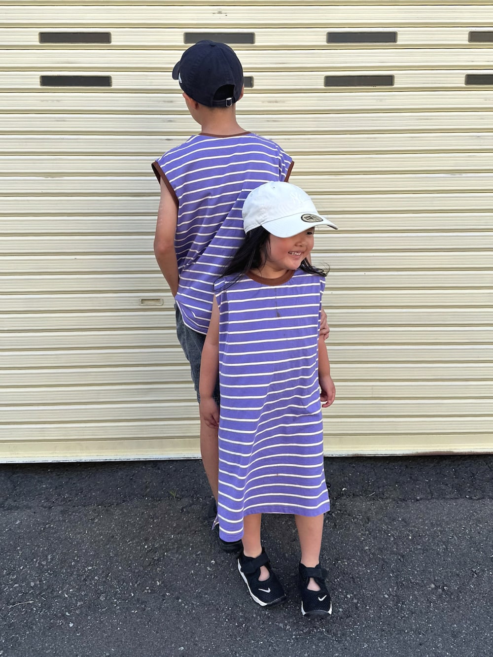 パープル系のTシャツ/カットソー、パープル系のワンピース、ブラック系のデニムパンツを着用したキッズの夏コーディネートの4枚目の写真