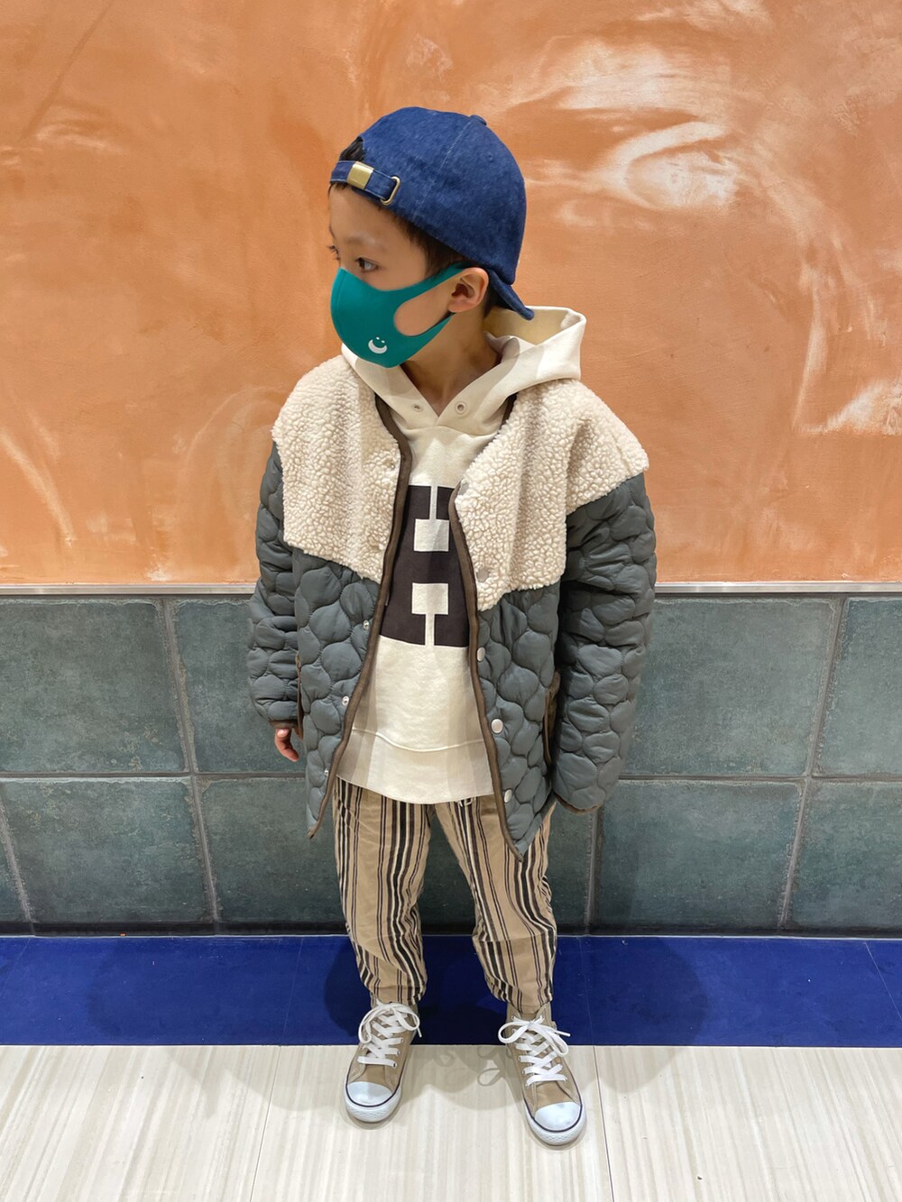 グリーン系のダウンジャケット/コート、ホワイト系のTシャツ/カットソー、ベージュ系のパンツを着用したキッズの冬コーディネートの2枚目の写真