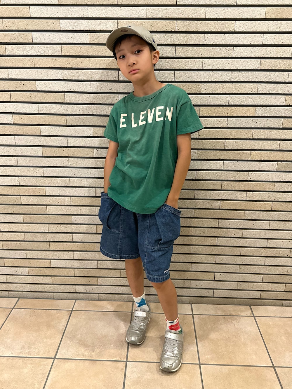 グリーン系のTシャツ/カットソー、ブルー系のデニムパンツ、シルバー系のスニーカーを着用したキッズの夏コーディネートの3枚目の写真