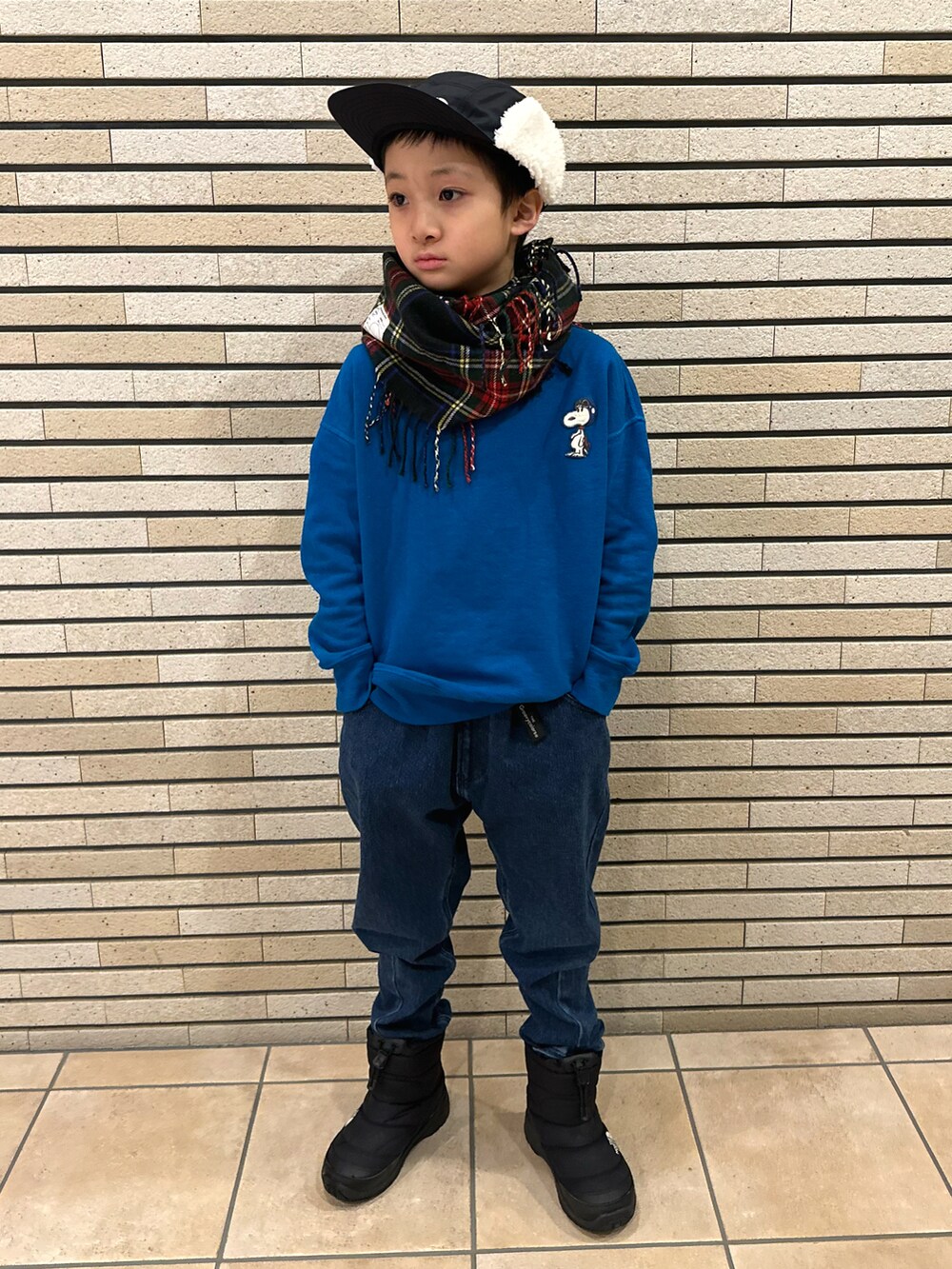 ブルー系のスウェット、ブルー系のデニムパンツ、ブラック系のブーツを着用したキッズの冬コーディネートの2枚目の写真