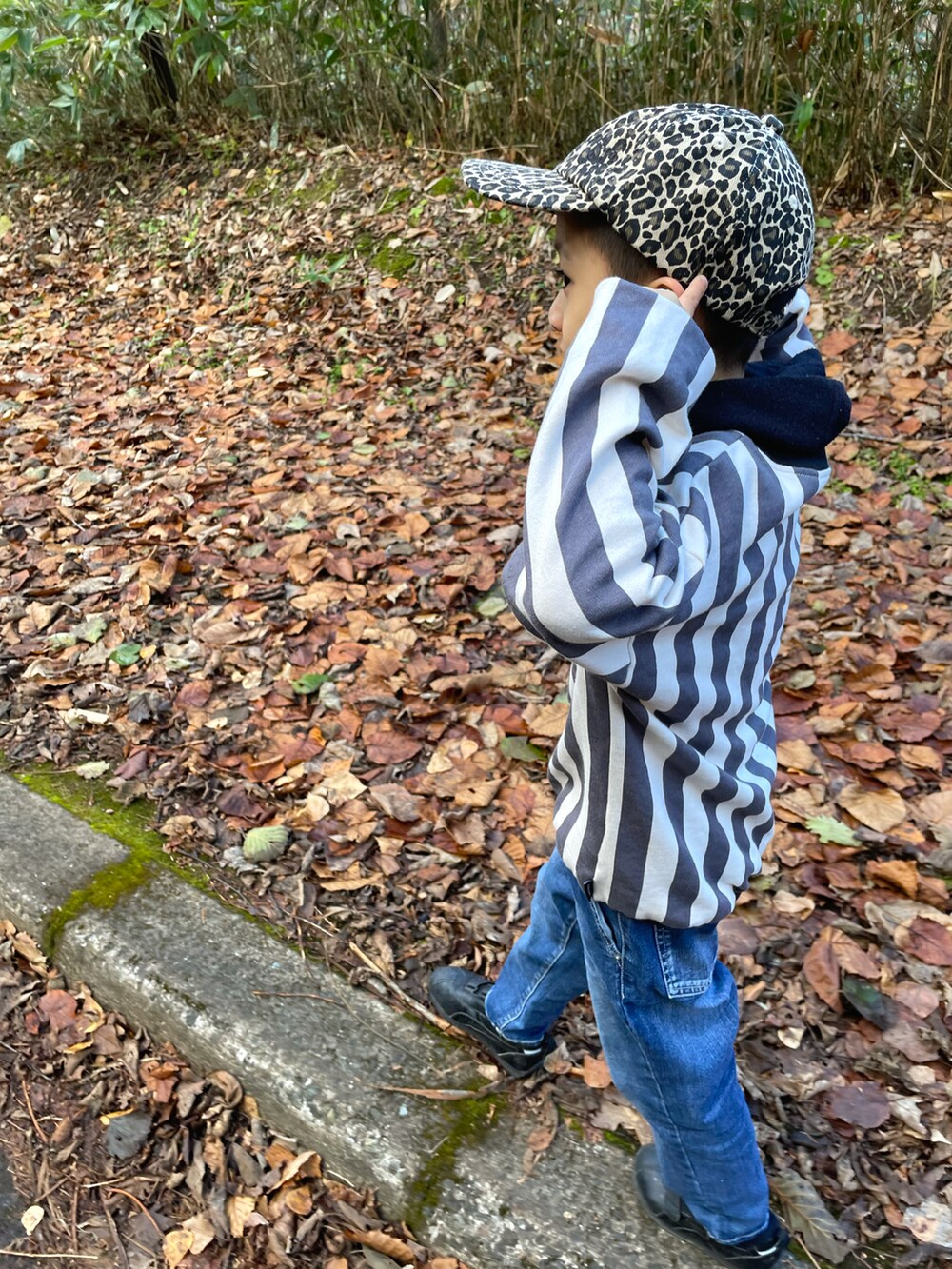 グレー系のスウェット、ブルー系のデニムパンツ、ブラック系のスニーカーを着用したキッズの冬コーディネートの4枚目の写真