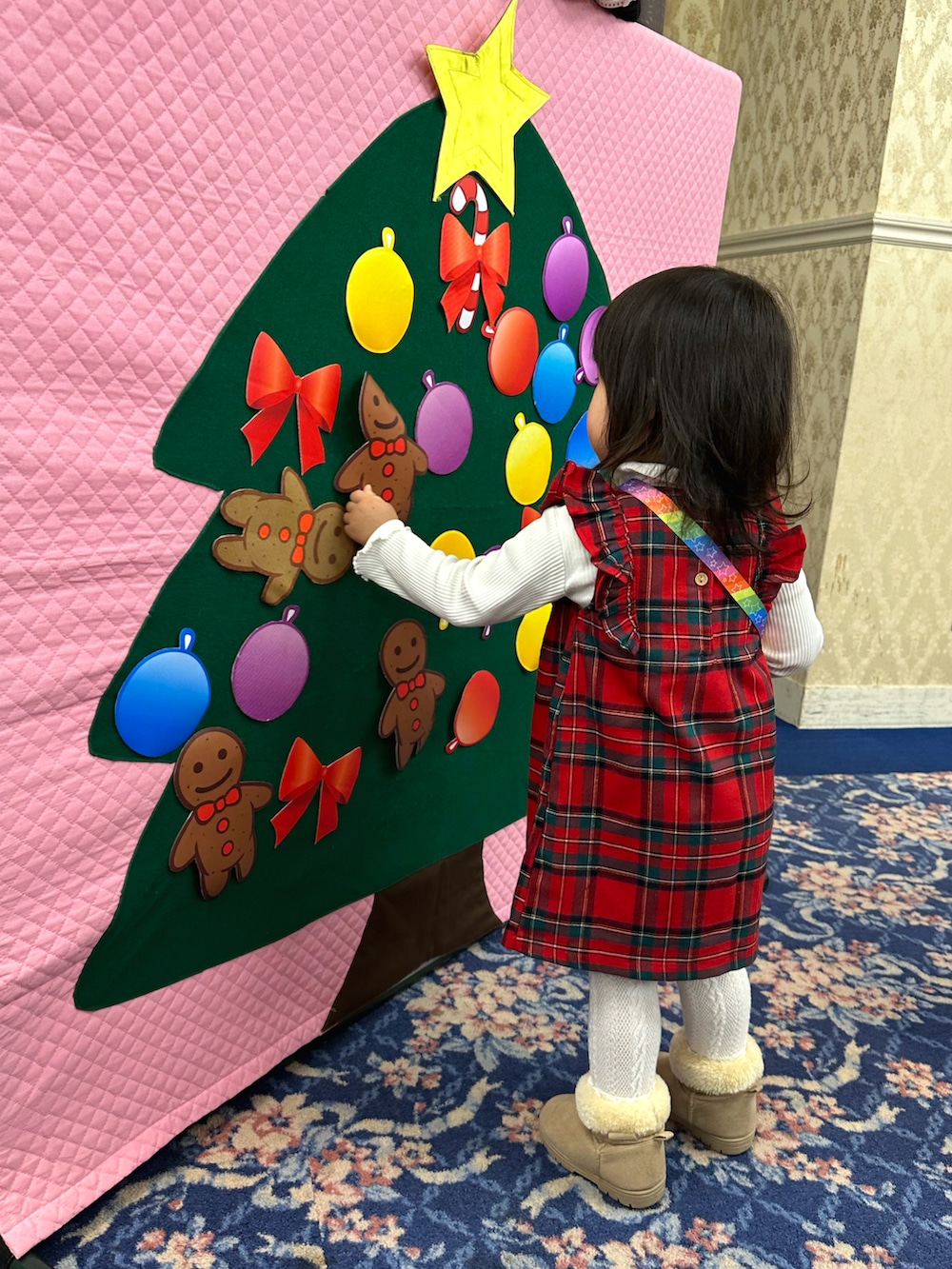 レッド系のワンピース、ホワイト系のその他トップス、ベージュ系のブーツを着用したキッズの冬コーディネートの3枚目の写真