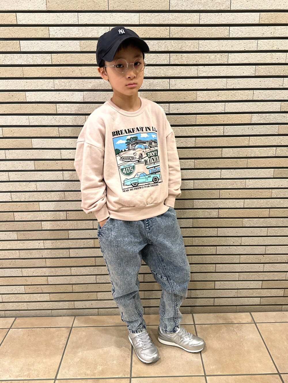 ピンク系のスウェット、その他のデニムパンツ、シルバー系のスニーカーを着用したキッズの春コーディネートの2枚目の写真