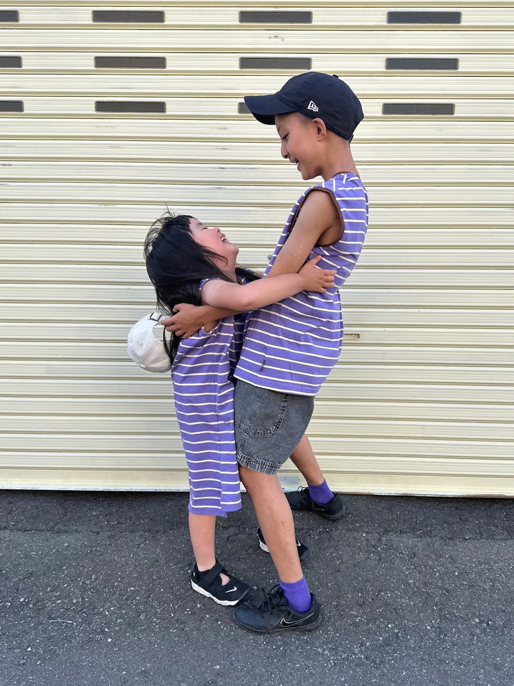 パープル系のTシャツ/カットソー、パープル系のワンピース、ブラック系のデニムパンツを着用したキッズの夏コーディネートの2枚目の写真