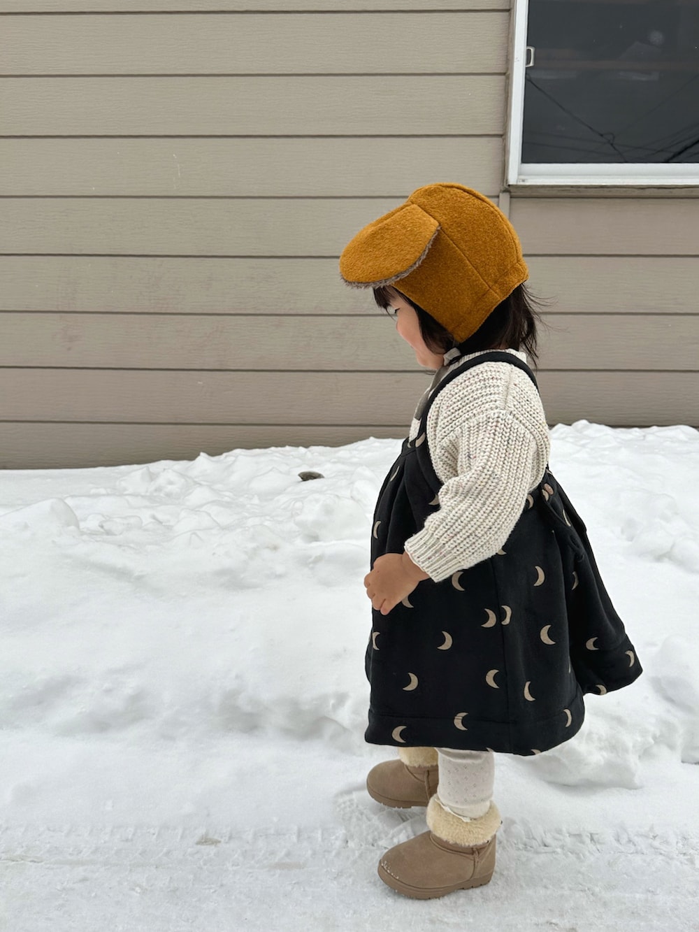 ホワイト系のニット/セーター、ブラック系のワンピース、ベージュ系のブーツを着用したキッズの冬コーディネートの4枚目の写真