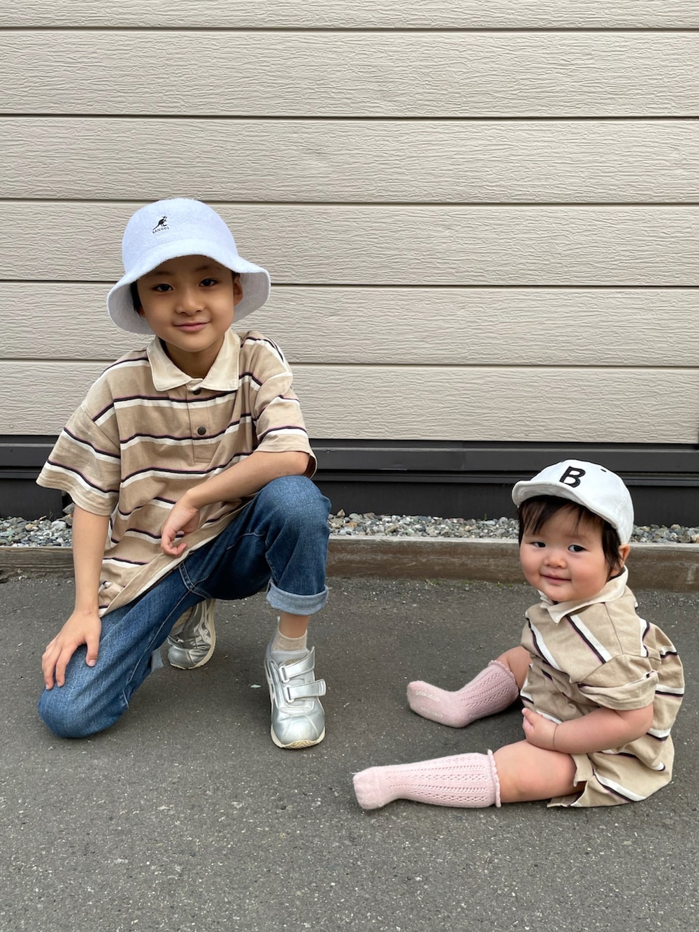 ベージュ系のポロシャツ、ブルー系のデニムパンツ、シルバー系のスニーカーを着用したキッズの春コーディネートの2枚目の写真