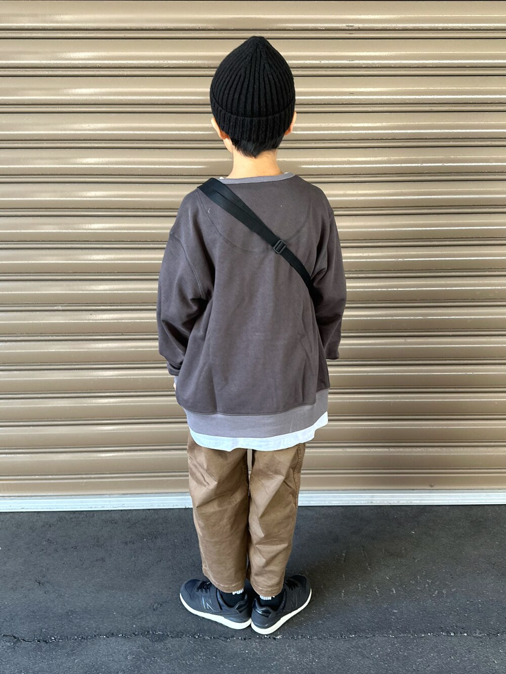 ブラック系のカーディガン/ボレロ、ホワイト系のTシャツ/カットソー、ブラウン系のチノパンツを着用したキッズの秋コーディネートの2枚目の写真